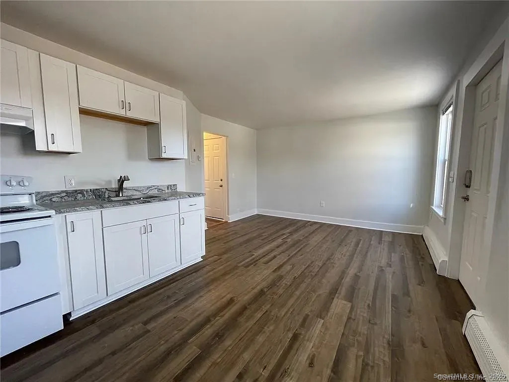30 Anthony Street, Unit C Griswold, CT 06351 - Photo 5 of 11 a kitchen with wooden floors and white cabinets