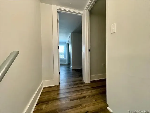 a view of a hallway with wooden floor