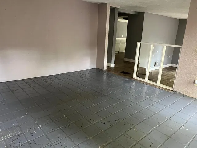 an empty room with wooden floor and mirror