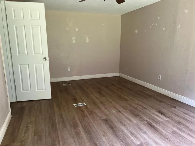 an empty room with wooden floor and closet area
