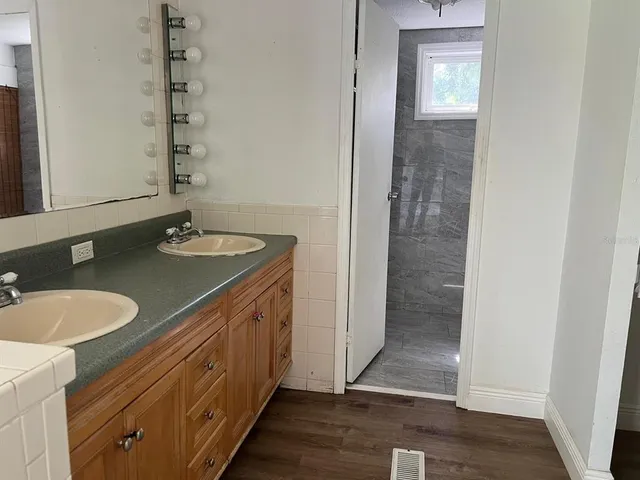 a bathroom with a granite countertop sink and a mirror