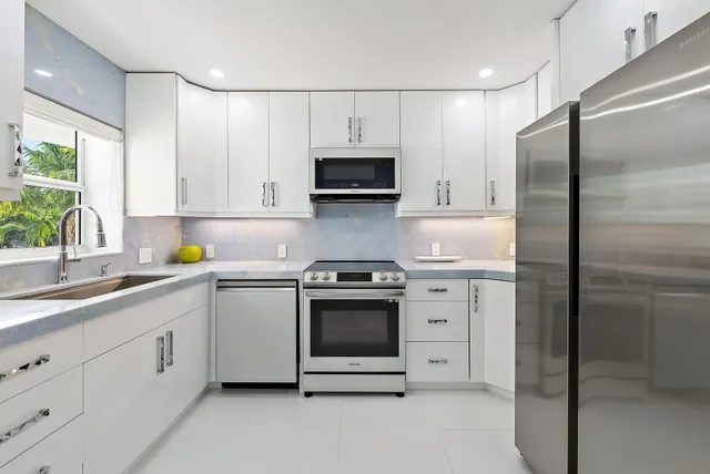 a kitchen with white cabinets and stainless steel appliances