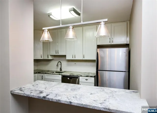 a kitchen with white cabinets and stainless steel appliances