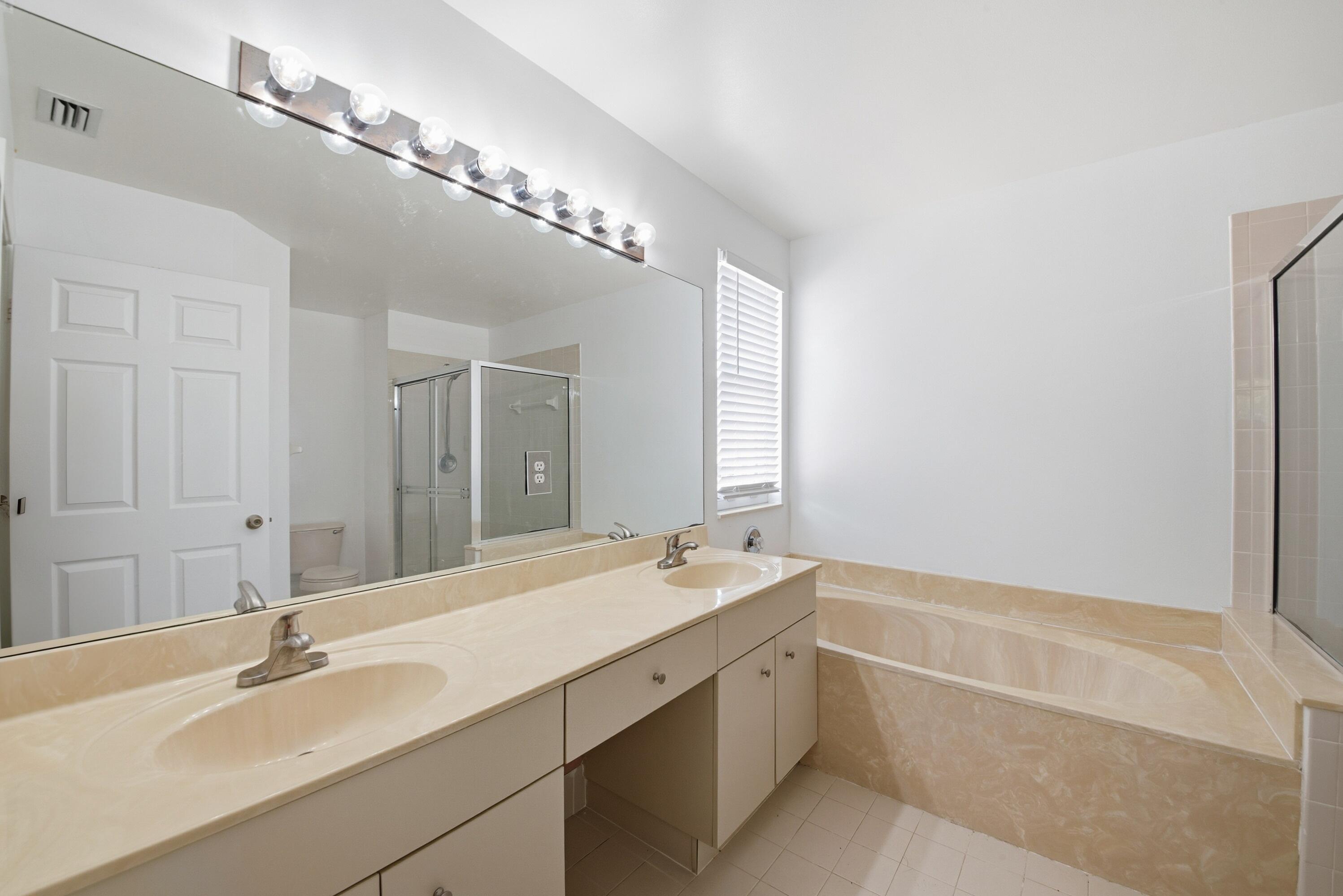 8021 Stirrup Cay Court Boynton Beach, FL 33436 - Photo 20 of 23 a bathroom with a tub a sink and mirror