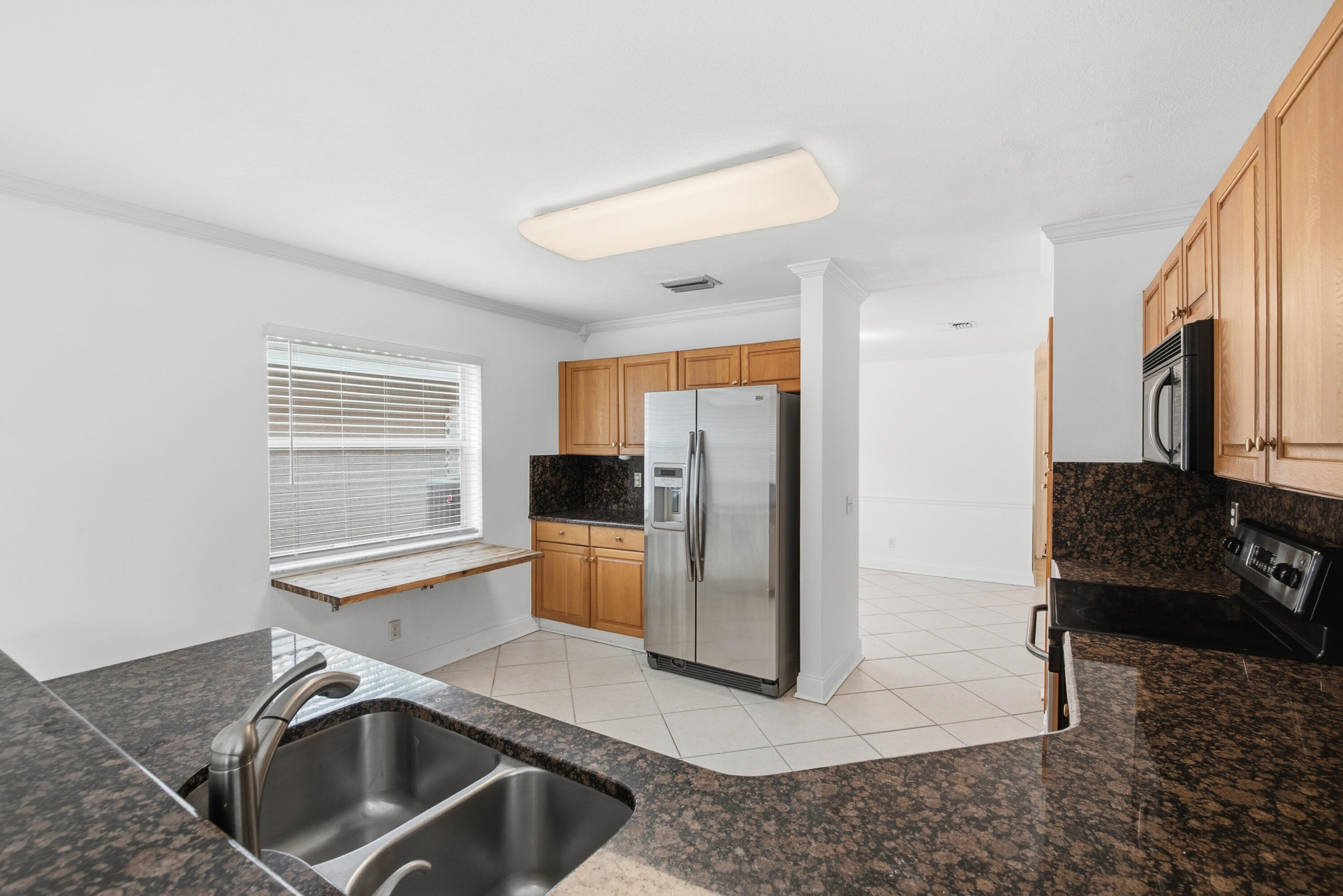 8021 Stirrup Cay Court Boynton Beach, FL 33436 - Photo 8 of 23 a kitchen with stainless steel appliances granite countertop a sink stove and refrigerator
