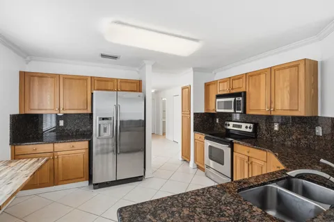 a kitchen with stainless steel appliances granite countertop a refrigerator and a sink