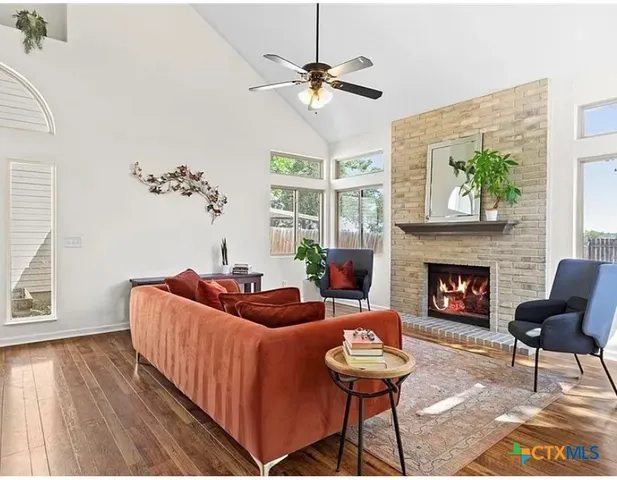 a living room with furniture a fireplace and a large window