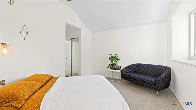a bedroom with a bed lamp and a potted plant