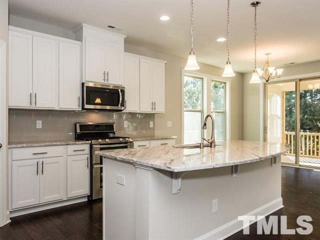 256 Alamosa Place Cary, NC 27519 - Photo 12 of 16 a kitchen with stainless steel appliances granite countertop a sink a stove and a microwave