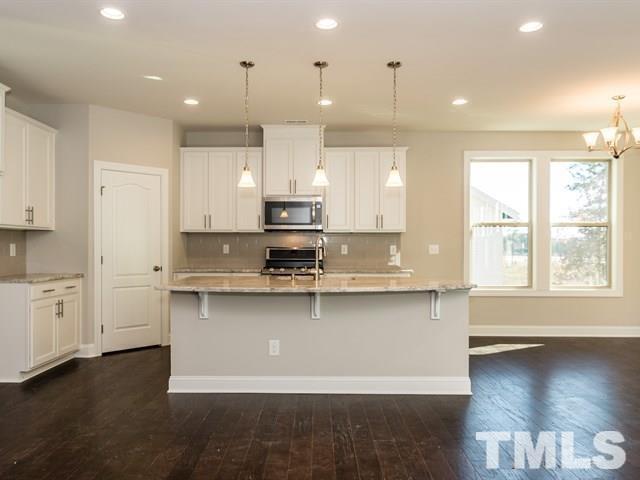 256 Alamosa Place Cary, NC 27519 - Photo 3 of 16 a large kitchen with stainless steel appliances a large center island attached withe living room