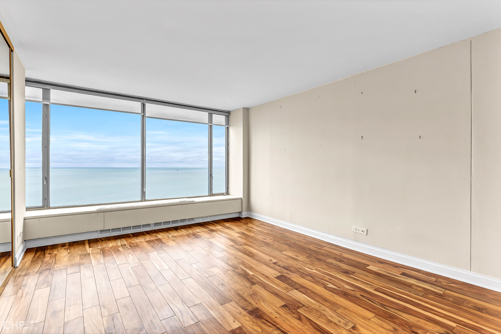 5455 North Sheridan Road, Unit 3501 Chicago, IL 60640 - Photo 12 of 29 an empty room with wooden floor and windows