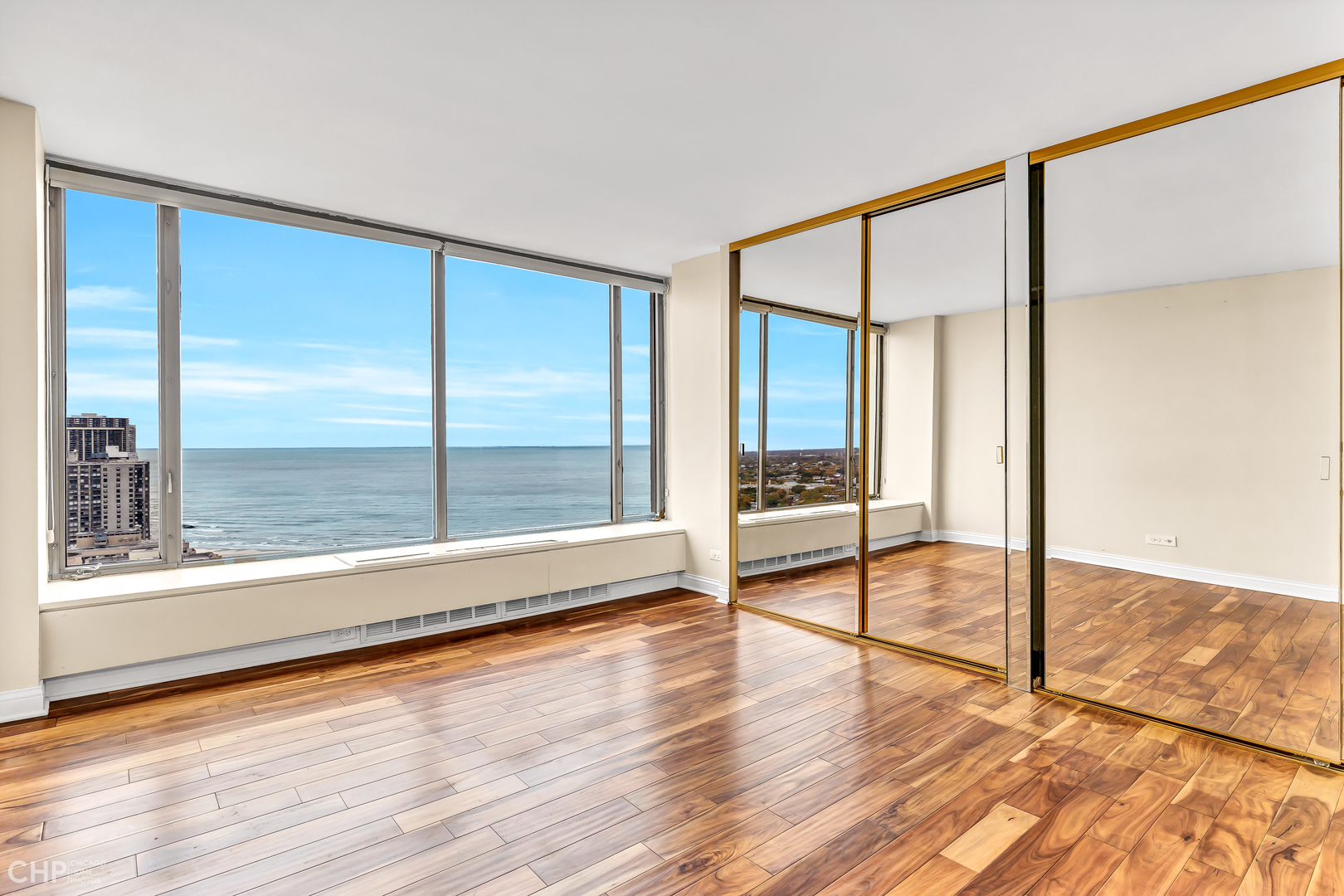 5455 North Sheridan Road, Unit 3501 Chicago, IL 60640 - Photo 17 of 29 a view of an empty room with wooden floor and a window