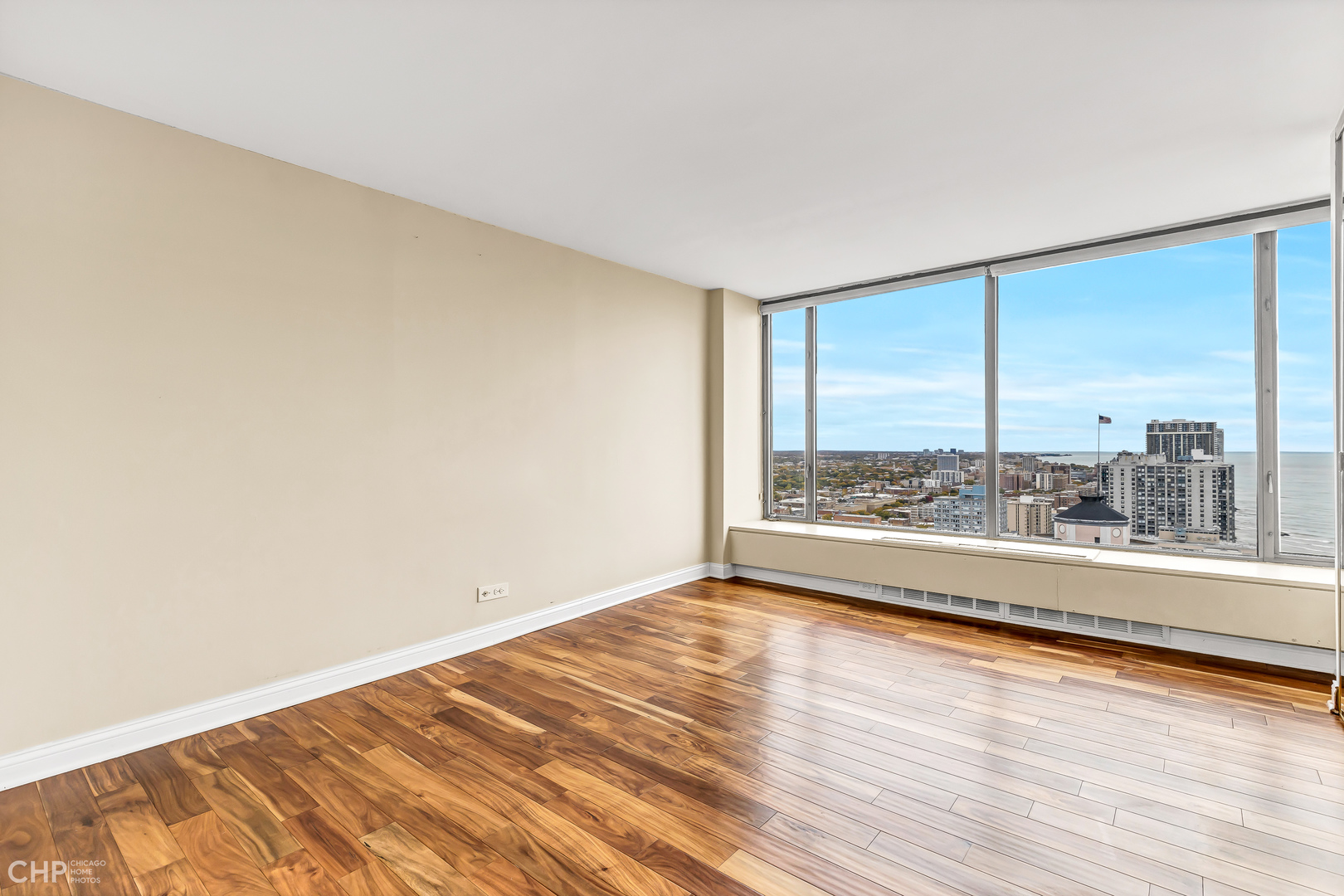 5455 North Sheridan Road, Unit 3501 Chicago, IL 60640 - Photo 19 of 29 an empty room with wooden floor and windows