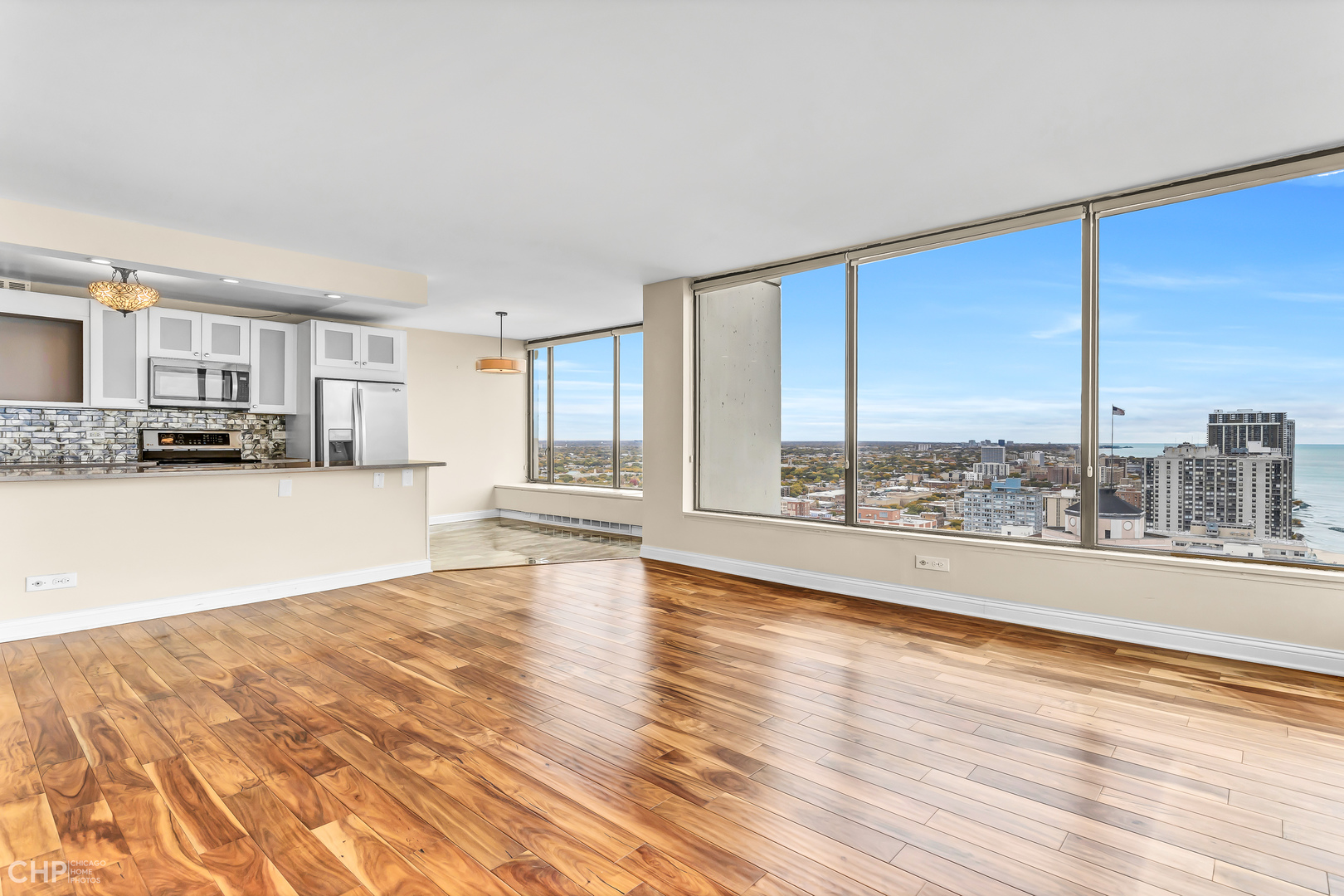 5455 North Sheridan Road, Unit 3501 Chicago, IL 60640 - Photo 3 of 29 a view of a living room with kitchen island furniture and a floor to ceiling window