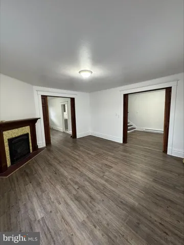 an empty room with wooden floor and fireplace