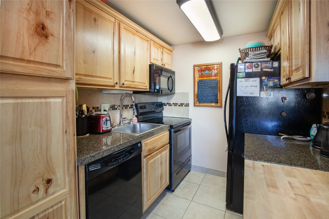 150 Evergreen Road, Unit 203 Dillon, CO 80435 - Photo 3 of 34 a kitchen with stainless steel appliances granite countertop a refrigerator and a sink