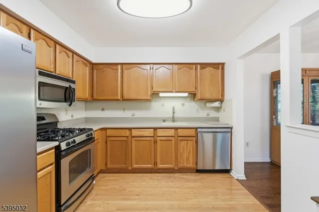 a kitchen with granite countertop a refrigerator stove top oven and sink