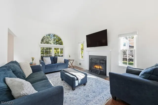 a living room with furniture a fireplace and a flat screen tv