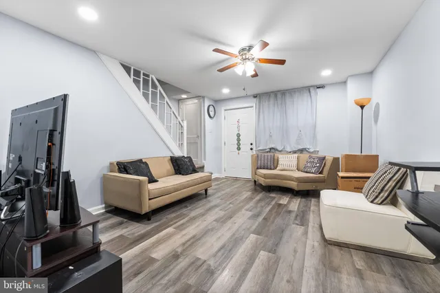 a dining room with wooden floor a ceiling fan and a window