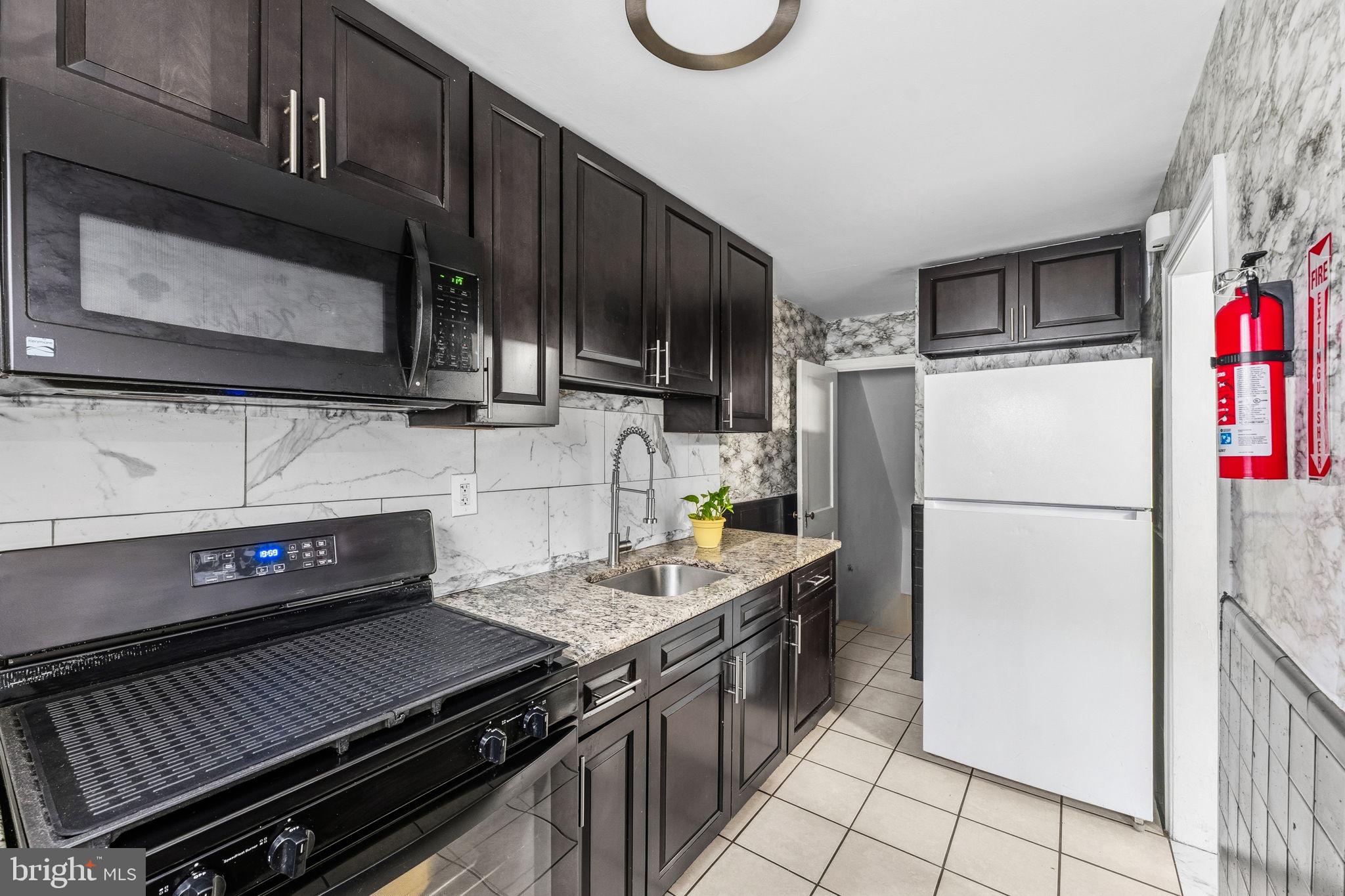 540 Snowden Road Upper Darby, PA 19082 - Photo 8 of 30 a kitchen with a stove and a microwave
