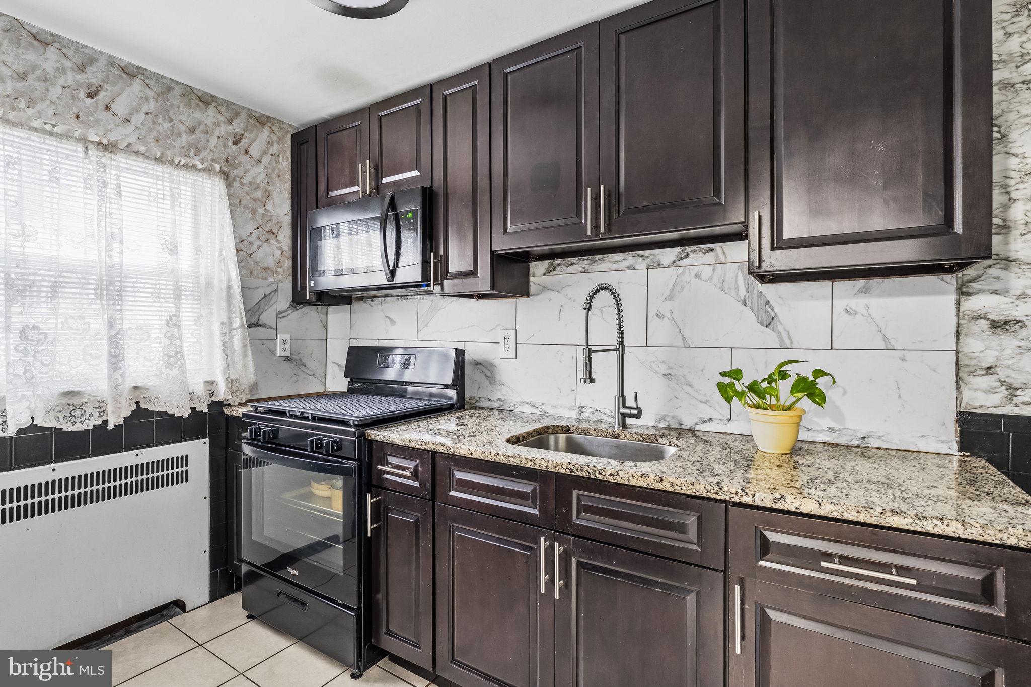 540 Snowden Road Upper Darby, PA 19082 - Photo 9 of 30 a kitchen with stainless steel appliances granite countertop a sink stove and cabinets