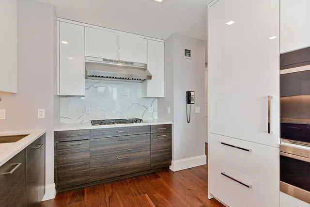 a kitchen with granite countertop white cabinets and stainless steel appliances