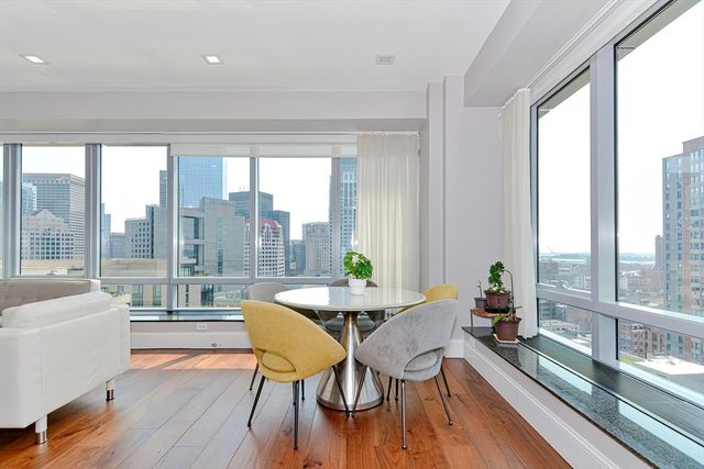 a dining room with furniture a chandelier and wooden floor