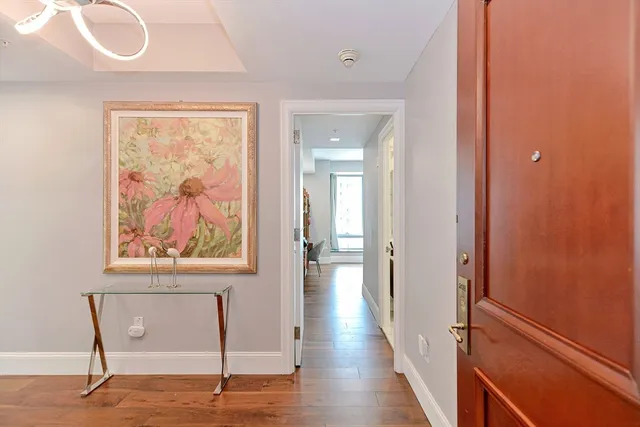 a view of a hallway with wooden floor and a bookshelf