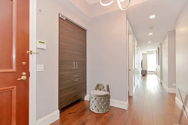 a view of a hallway with wooden floor and furniture