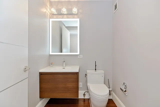a bathroom with a toilet a sink and mirror