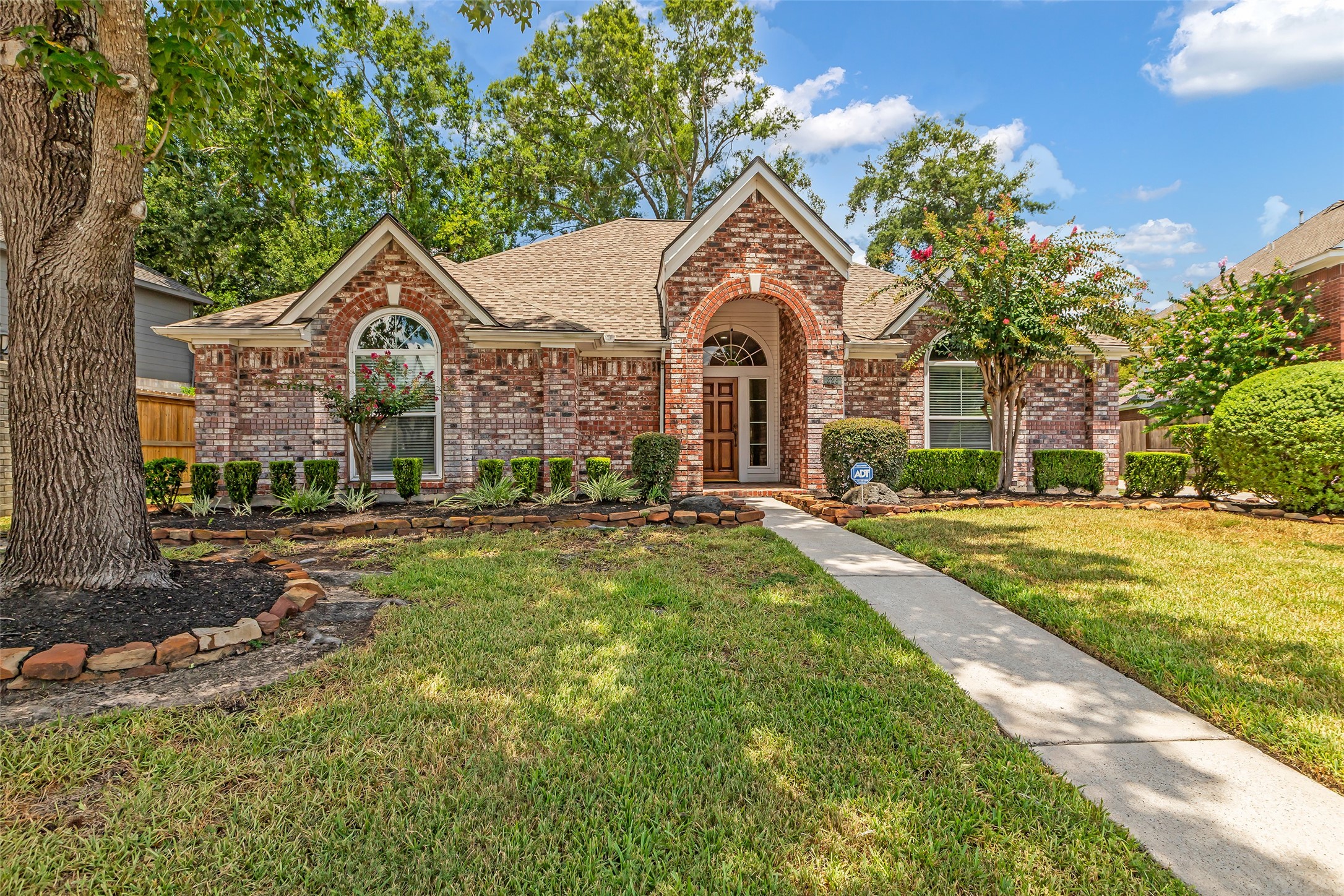 a front view of a house with yard and green space
