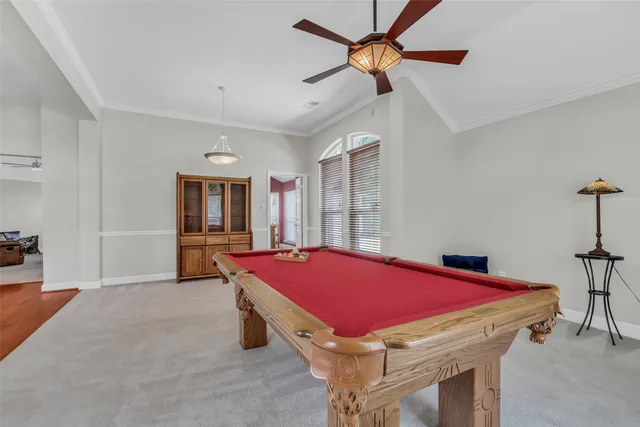 a room with pool table and windows