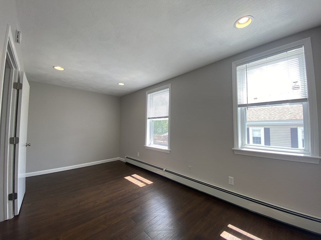 36 Upham Street, Unit 2 Salem, MA 01970 - Photo 11 of 13 an empty room with wooden floor and windows