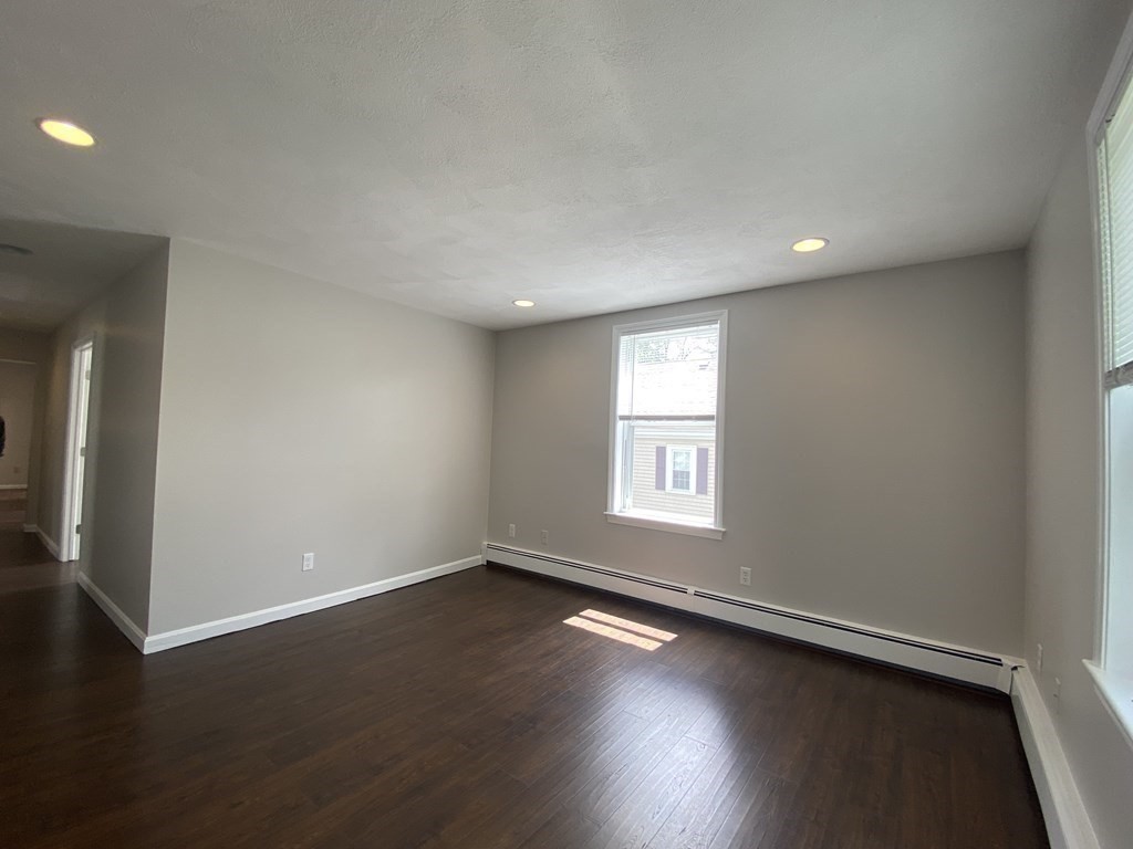 36 Upham Street, Unit 2 Salem, MA 01970 - Photo 3 of 13 an empty room with wooden floor and windows