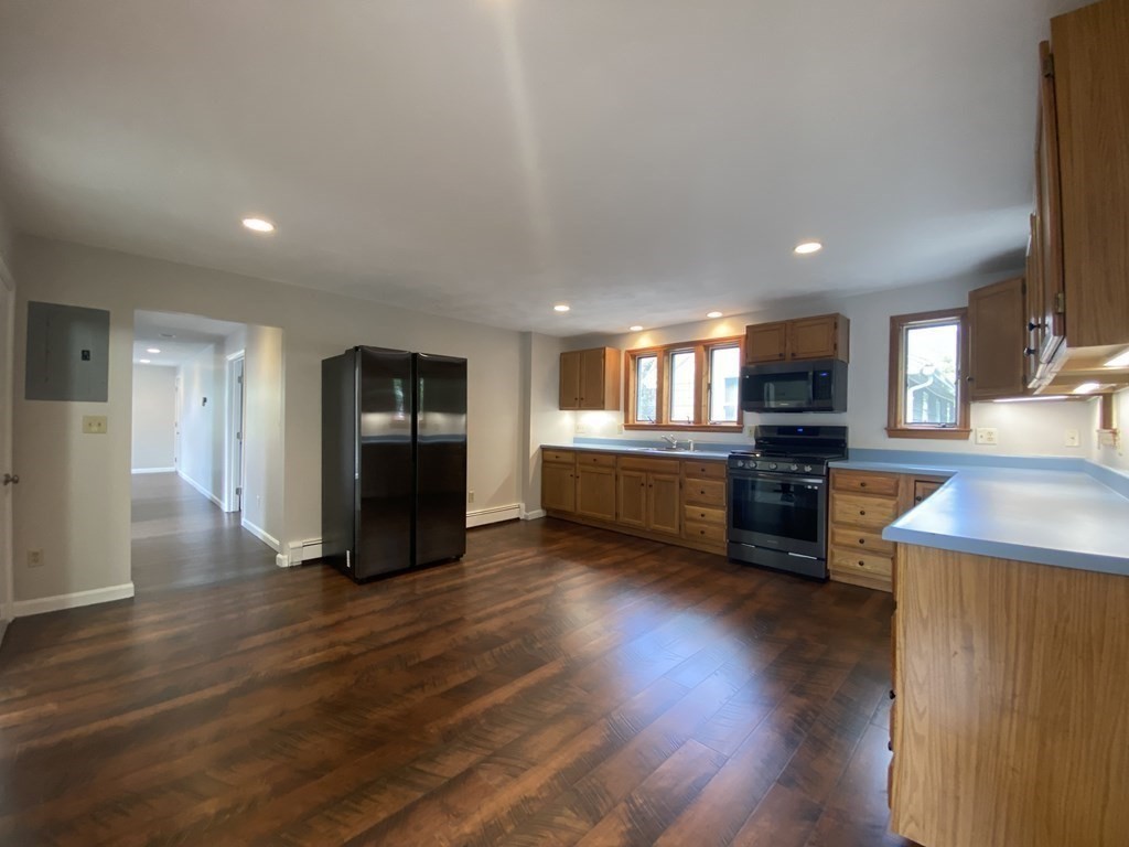 36 Upham Street, Unit 2 Salem, MA 01970 - Photo 5 of 13 a kitchen with stainless steel appliances kitchen island granite countertop a stove top oven a sink and a refrigerator