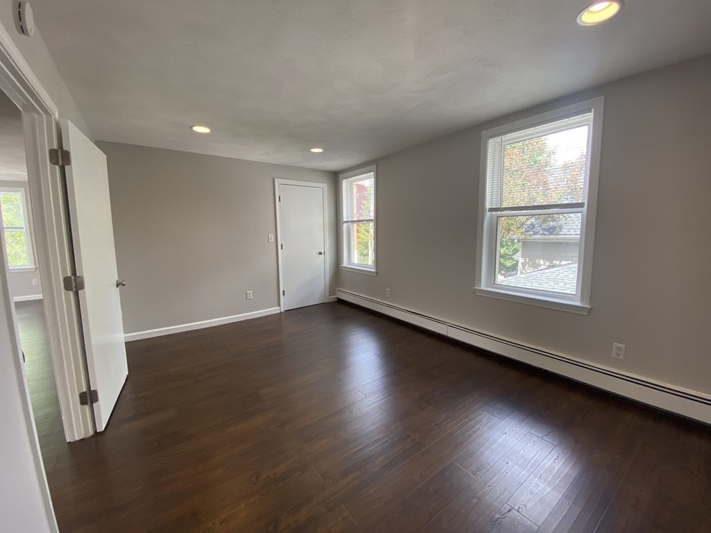 36 Upham Street, Unit 2 Salem, MA 01970 - Photo 7 of 13 an empty room with wooden floor and windows