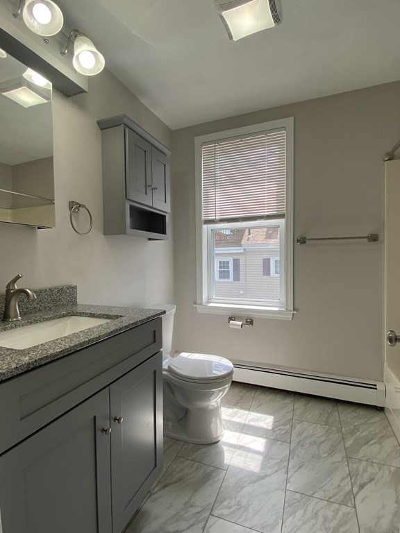 36 Upham Street, Unit 2 Salem, MA 01970 - Photo 9 of 13 a bathroom with a granite countertop sink a toilet and a mirror