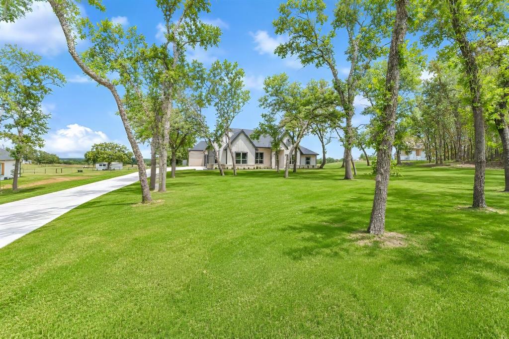1057 Vh Ranch Poolville, TX 76487 - Photo 38 of 38 a backyard of a house with lots of green space and fountain
