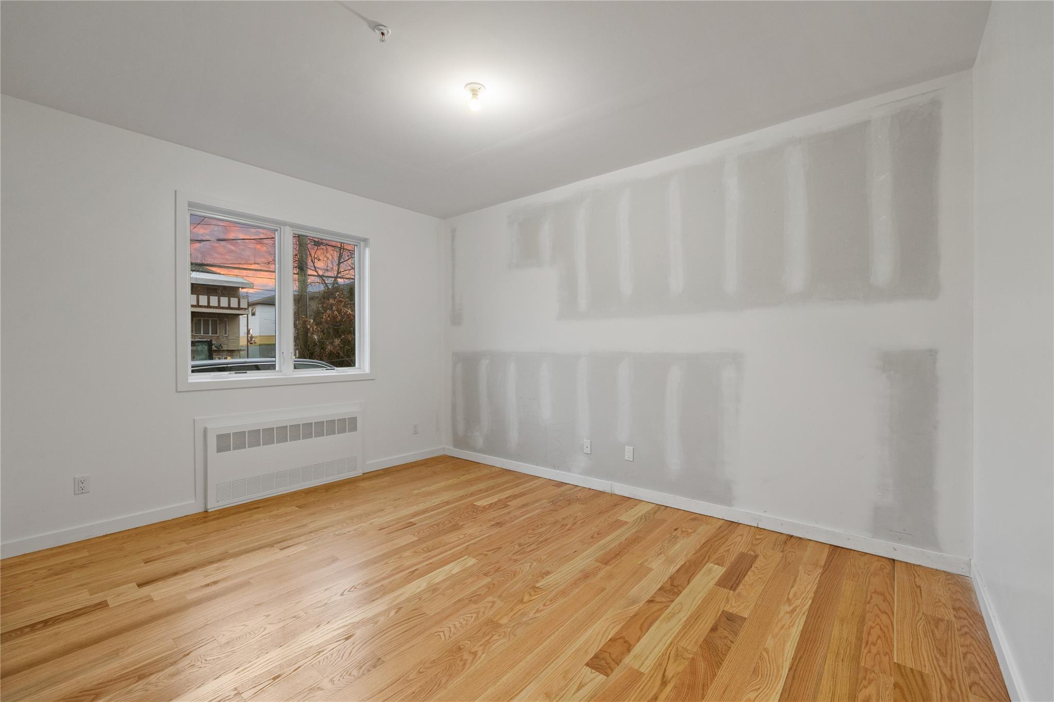 151 Blauvelt Road, Unit 116 Monsey, NY 10952 - Photo 11 of 12 a view of an empty room with wooden floor and a window