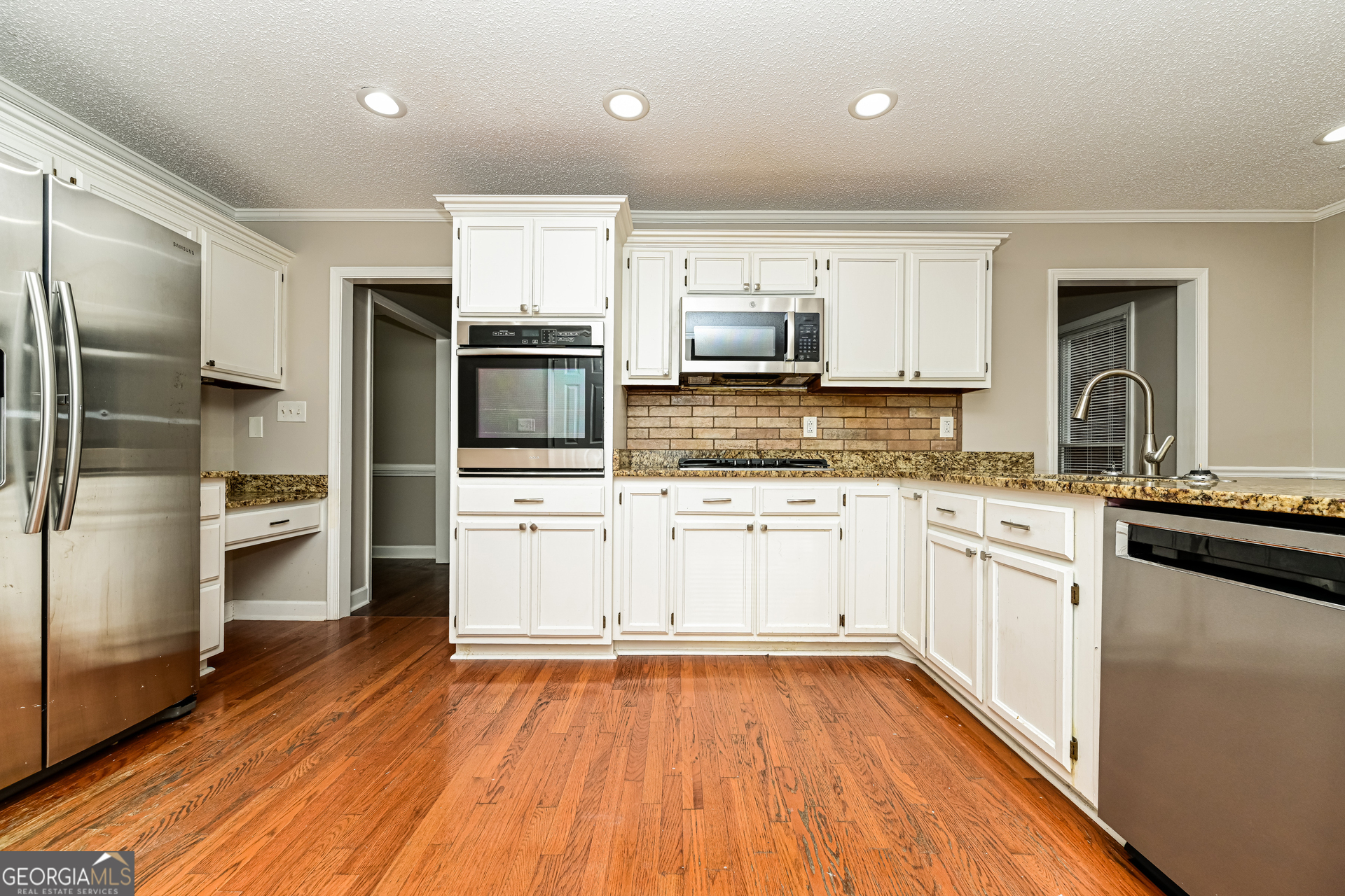 100 Red Maple Drive Hampton, GA 30228 - Photo 6 of 22 a kitchen with cabinets stainless steel appliances and wooden floor