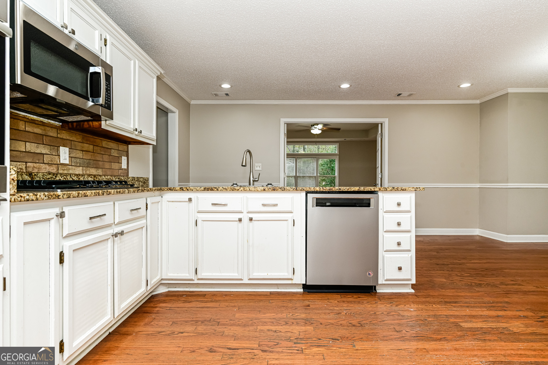 100 Red Maple Drive Hampton, GA 30228 - Photo 7 of 22 a kitchen with granite countertop a sink and a stove top oven with wooden floor