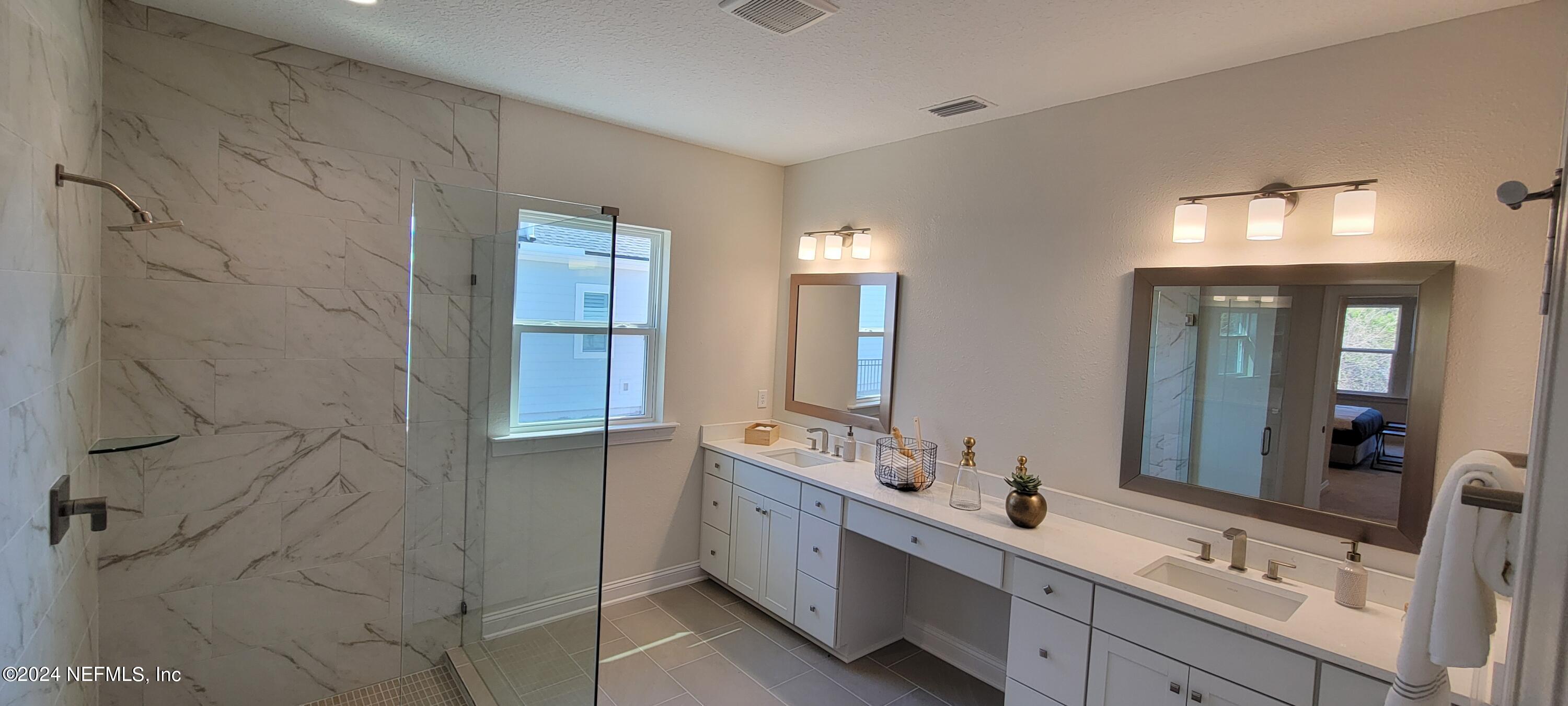 307 Ranch Land Circle St. Johns, FL 32259 - Photo 46 of 95 a bathroom with a double vanity sink a large mirror and shower