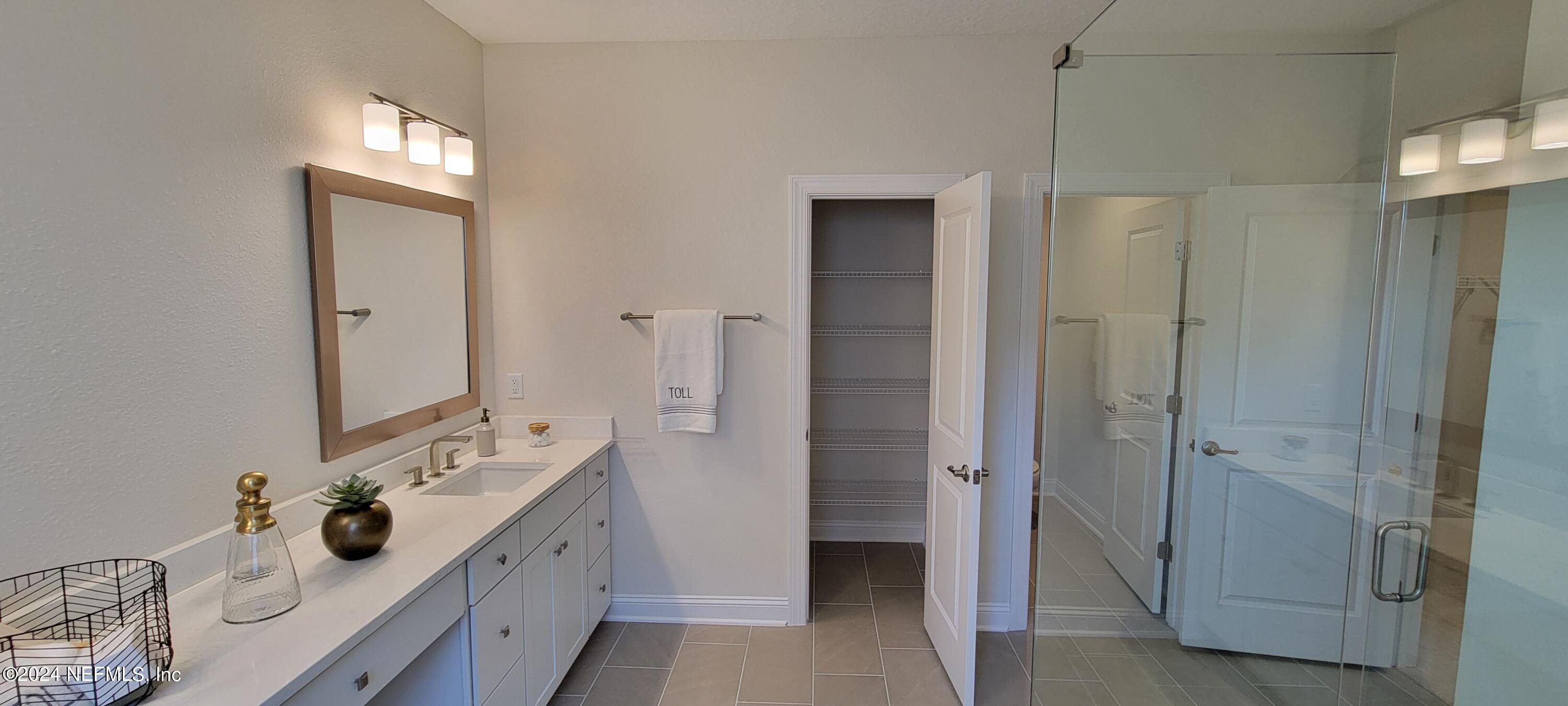 307 Ranch Land Circle St. Johns, FL 32259 - Photo 47 of 95 a spacious bathroom with a double vanity sink a large mirror and shower