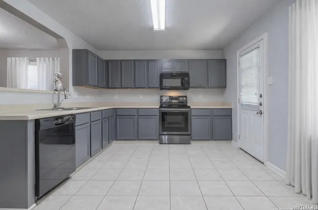 a kitchen with stainless steel appliances a sink stove and cabinets