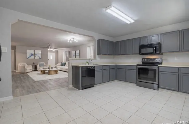 a kitchen with stainless steel appliances granite countertop a stove top oven a sink dishwasher and a refrigerator