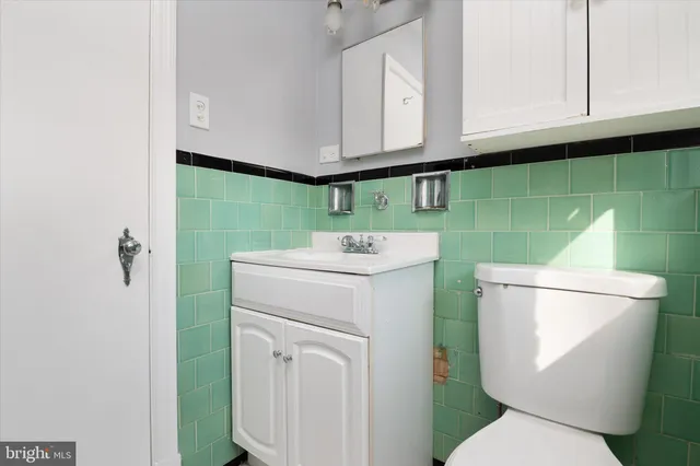 a bathroom with a toilet sink and mirror