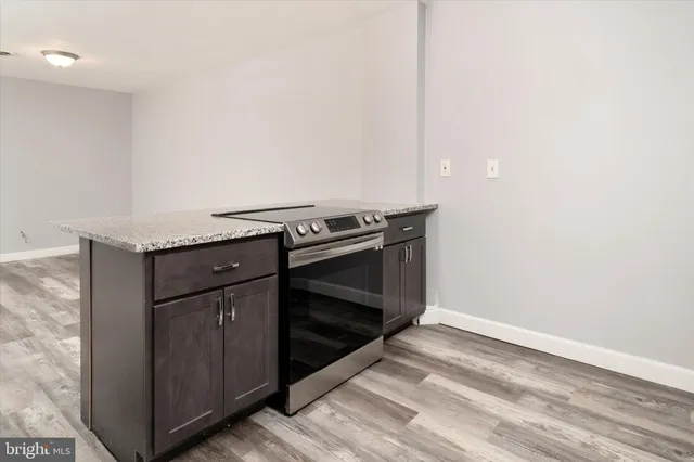 a kitchen with granite countertop a stove and a microwave
