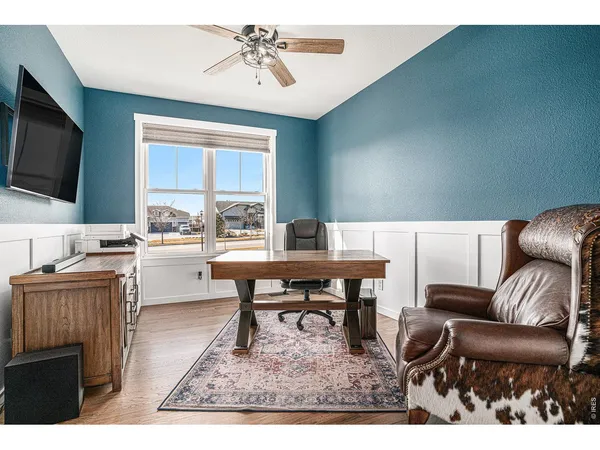 a living room with furniture a flat screen tv and kitchen view