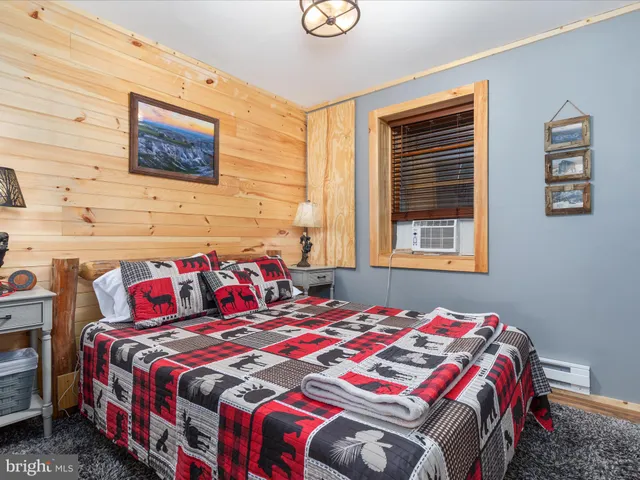 a spacious bedroom with a bed and wooden floor