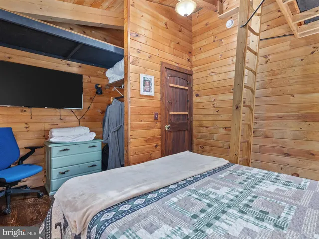 a bedroom with bed and wooden floor